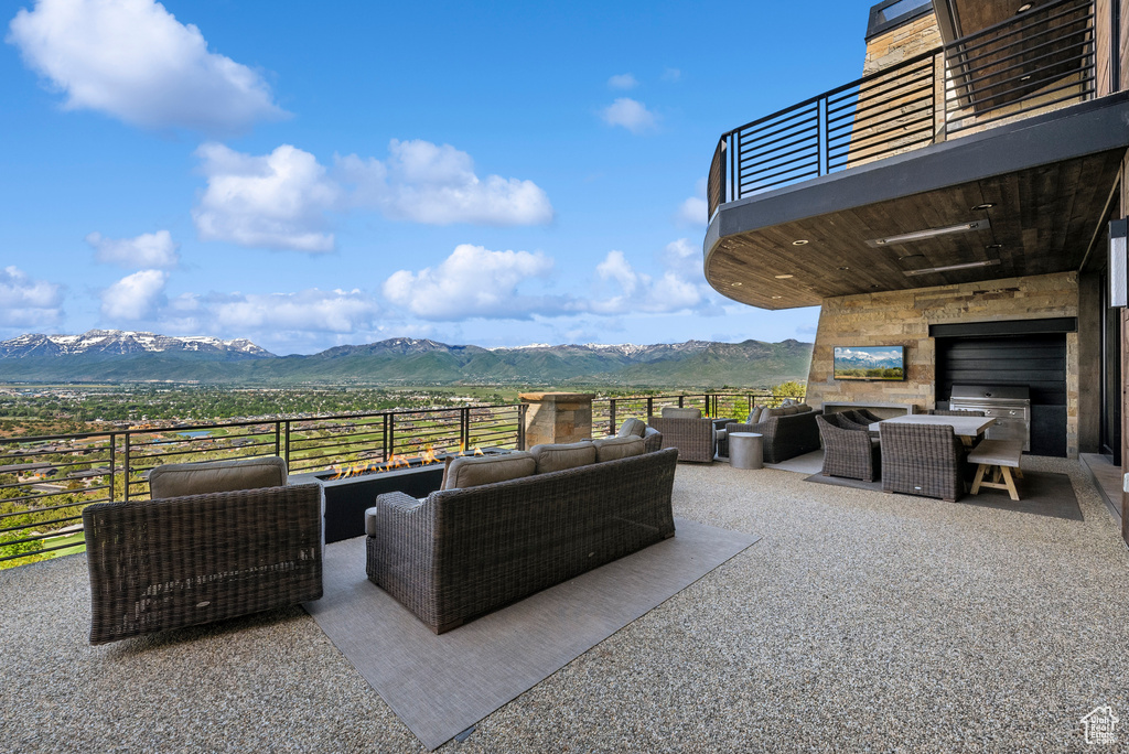 View of patio / terrace with an outdoor living space with a fireplace, a balcony, and outdoor dining area