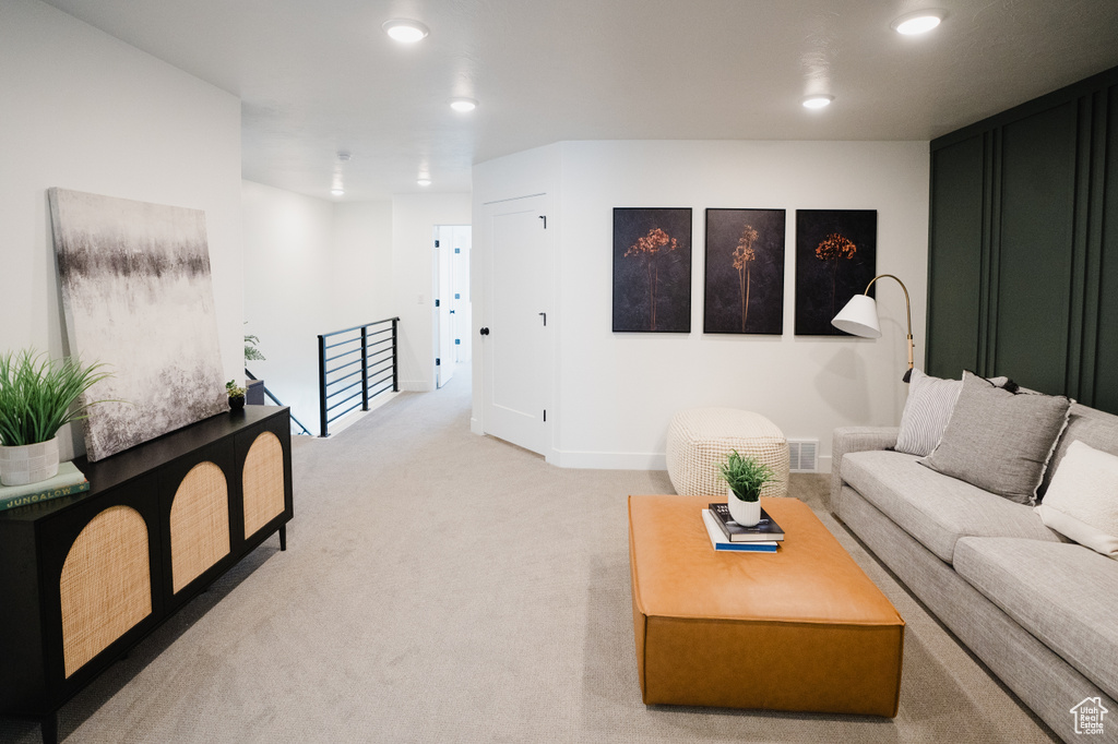 Carpeted living area featuring recessed lighting and baseboards