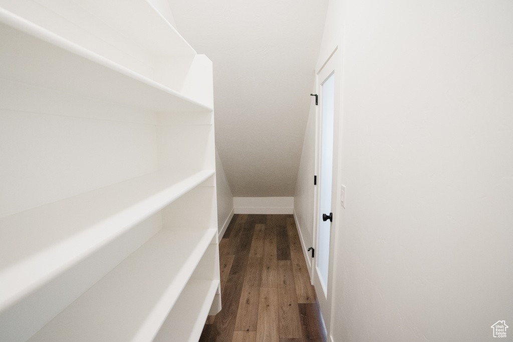 Hallway featuring dark wood finished floors and baseboards