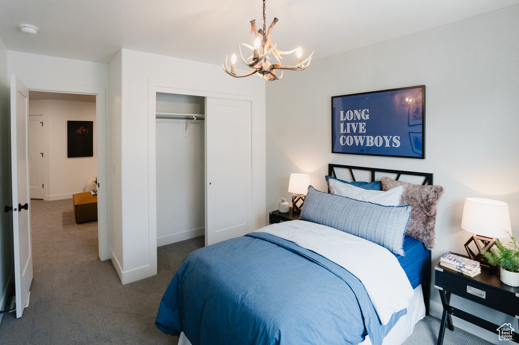 Bedroom featuring a chandelier, carpet, a closet, and baseboards