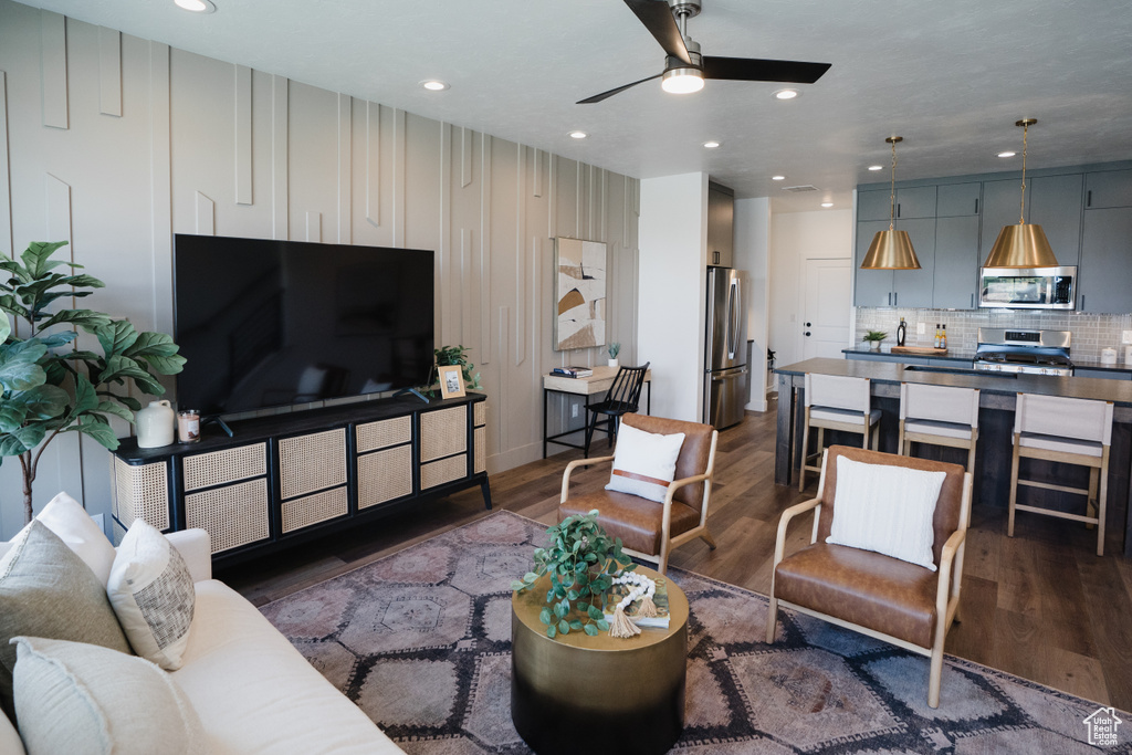 Living room with dark wood-style floors, ceiling fan, and recessed lighting