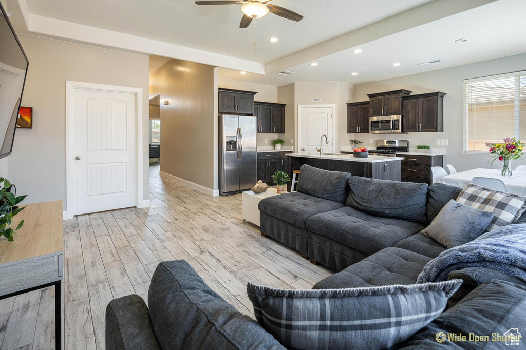 Living room featuring ceiling fan, recessed lighting, light wood-style flooring, and baseboards