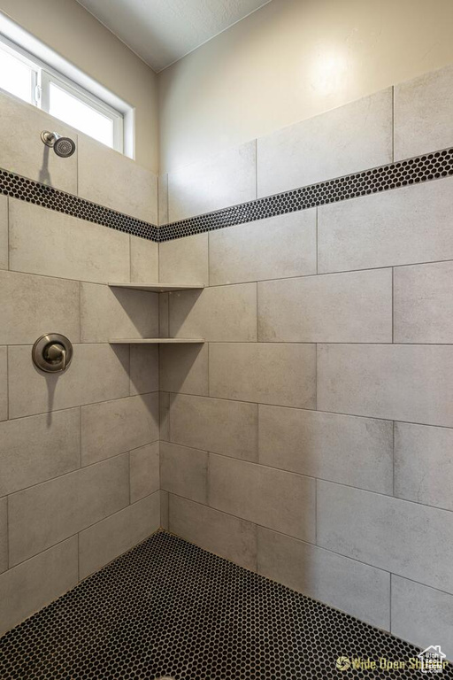 Full bath featuring tiled shower