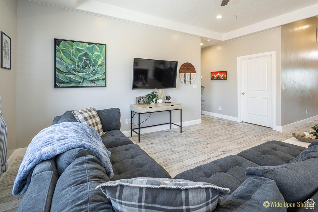 Living area featuring wood finished floors, baseboards, ceiling fan, and recessed lighting