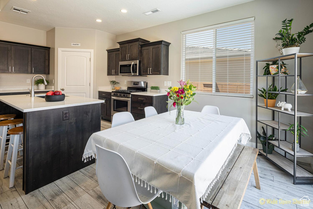 Dining space with light wood-type flooring, recessed lighting, and baseboards
