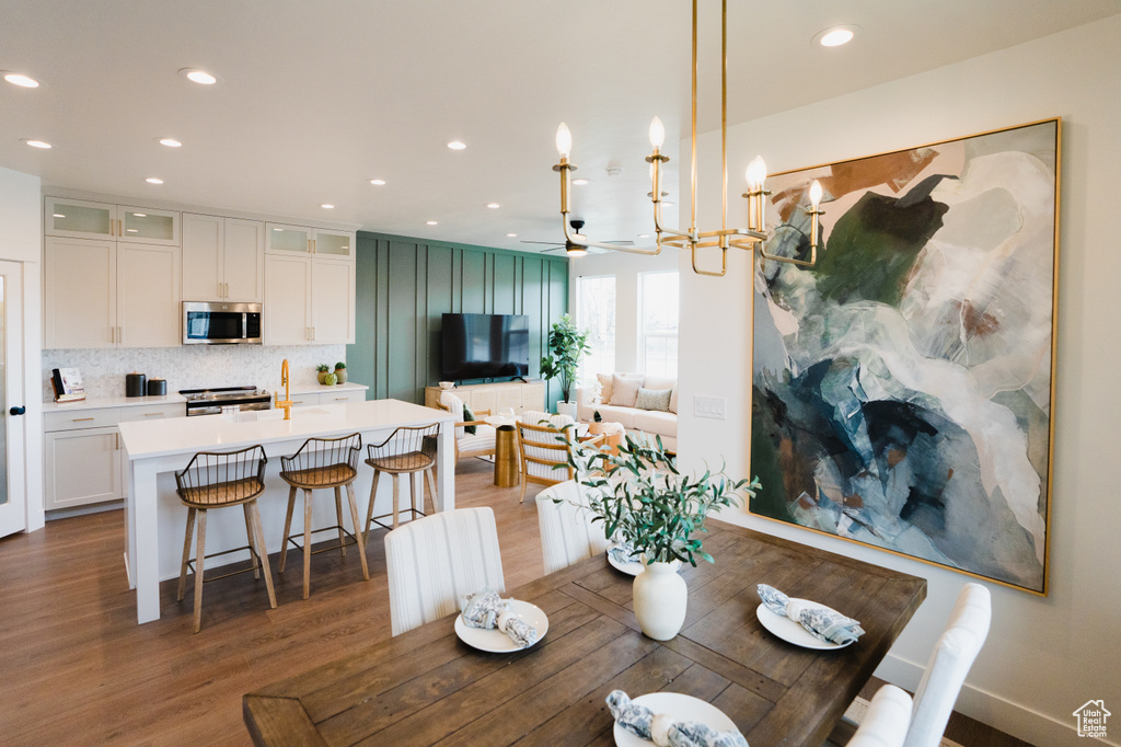 Dining space with wood finished floors, recessed lighting, ceiling fan, and a chandelier