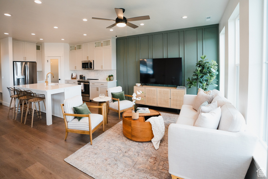 Living area featuring wood finished floors, ceiling fan, and recessed lighting
