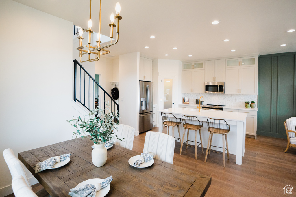 Dining room featuring recessed lighting, light wood-style floors, stairway, and a chandelier