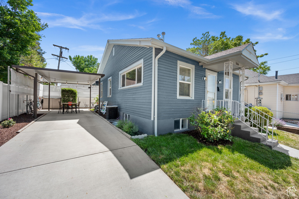 View of home\\\\\\\\\\\\\\\'s exterior featuring central AC unit, concrete driveway, and a carport