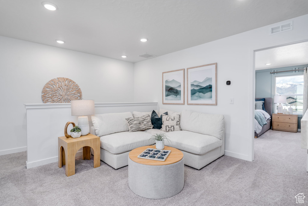 Carpeted living area with recessed lighting and baseboards