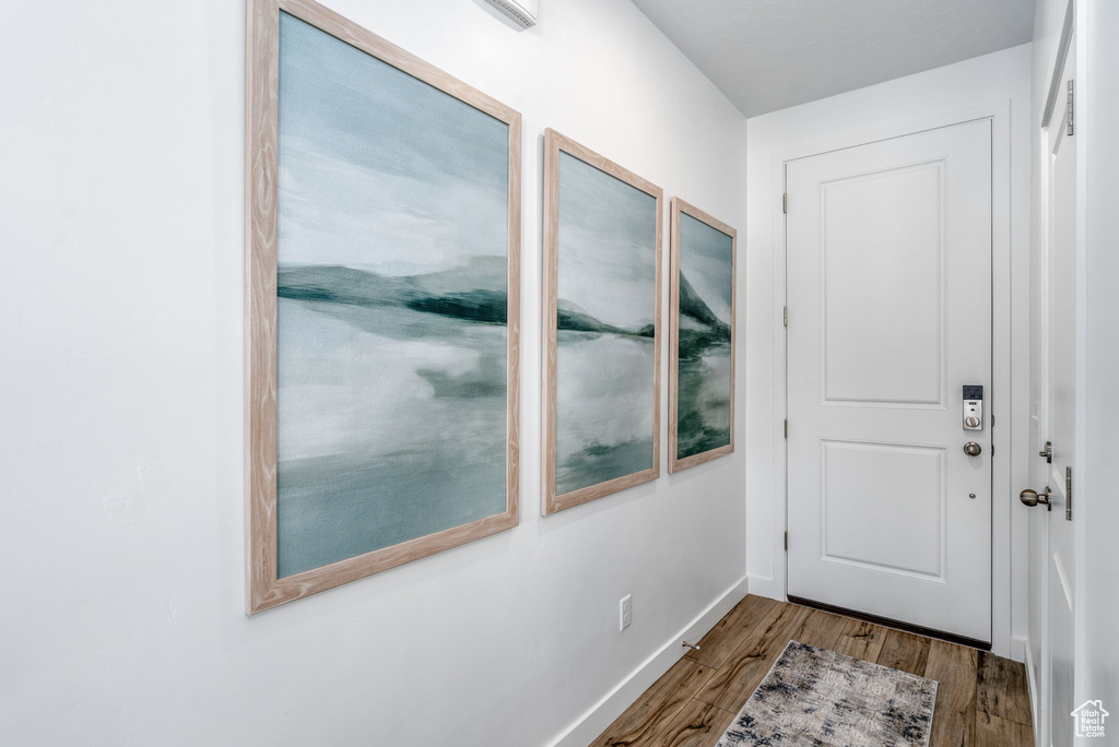 Doorway with wood finished floors and baseboards