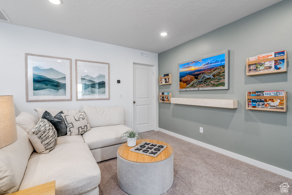 Living area with carpet, baseboards, and recessed lighting