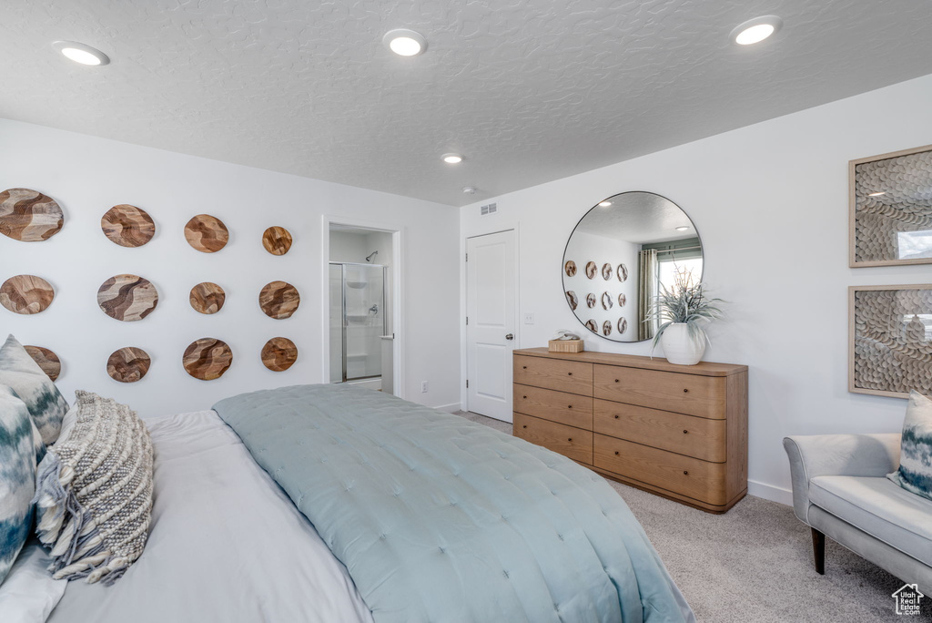 Bedroom with light carpet, baseboards, recessed lighting, and connected bathroom