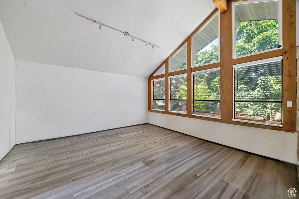 Bonus room featuring lofted ceiling, plenty of natural light, and wood finished floors