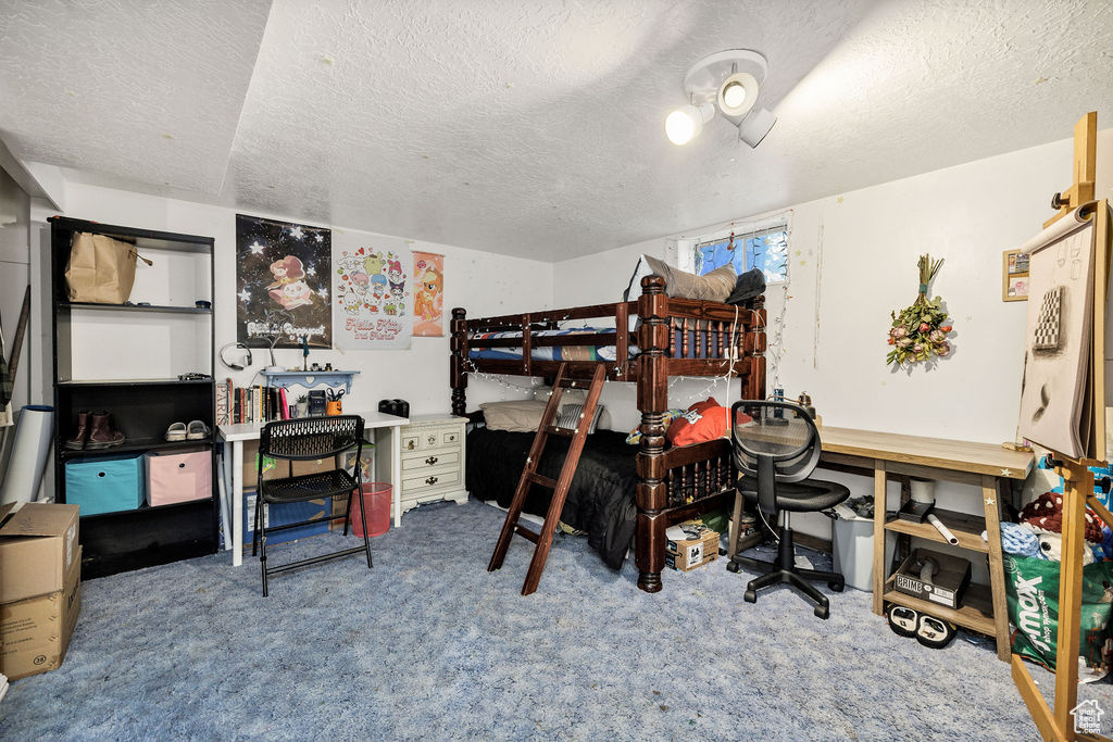 Carpeted bedroom with a textured ceiling
