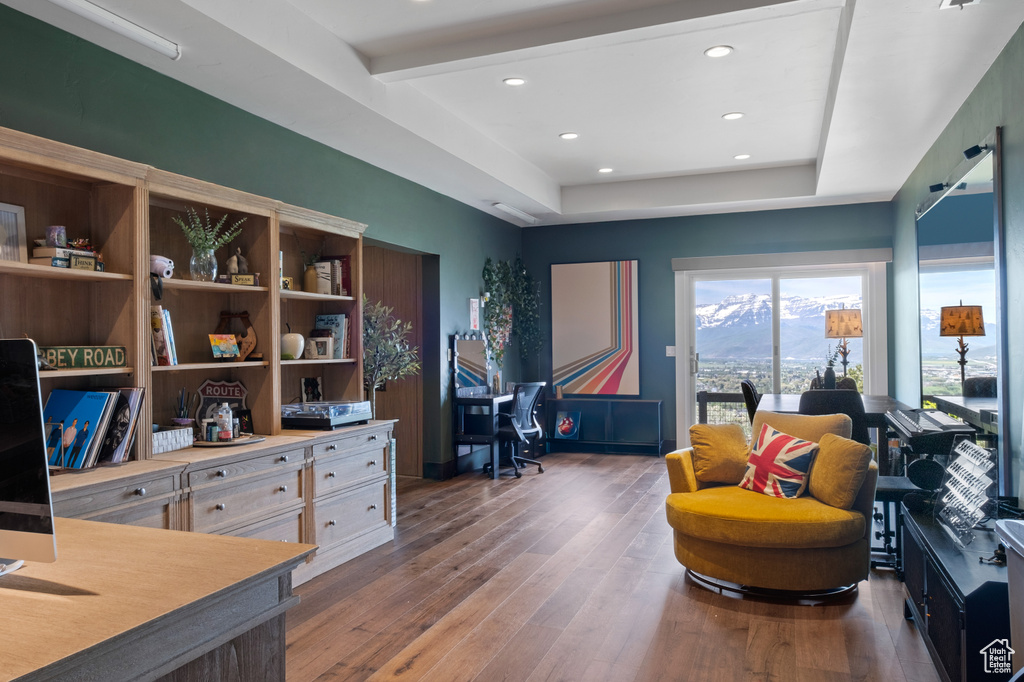 Home office featuring hardwood / wood-style floors, a raised ceiling, and recessed lighting