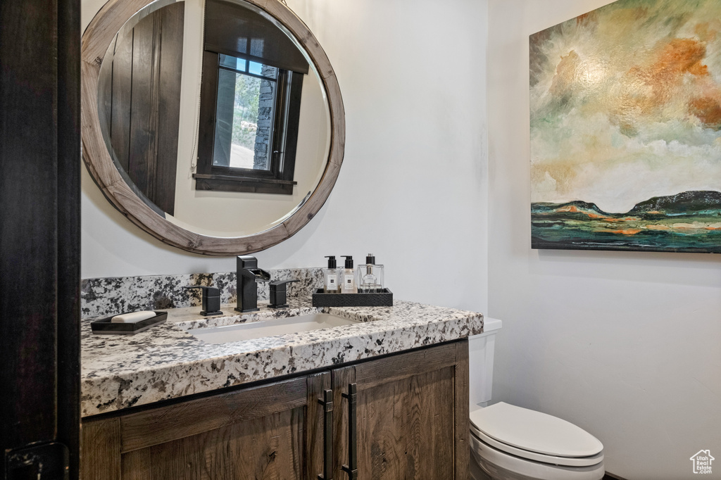 Half bathroom with vanity and toilet
