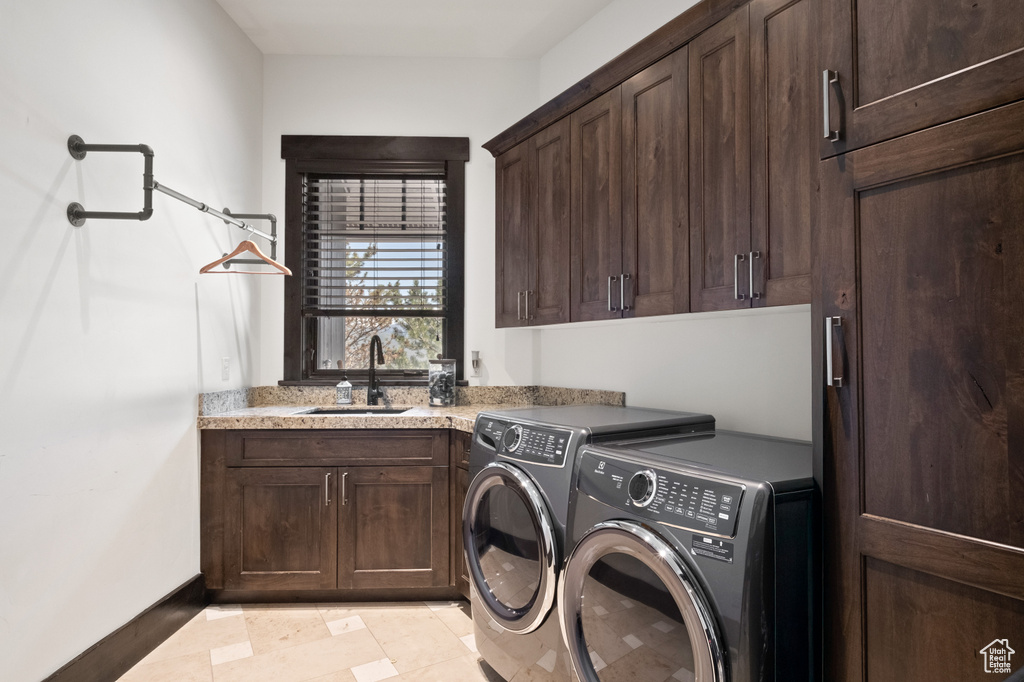 Laundry area featuring cabinet space, independent washer and dryer, baseboards, and light tile patterned flooring