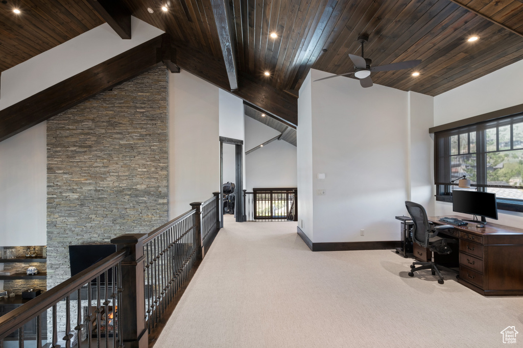 Carpeted office space with high vaulted ceiling, wood ceiling with exposed beams, ceiling fan, baseboards, and recessed lighting