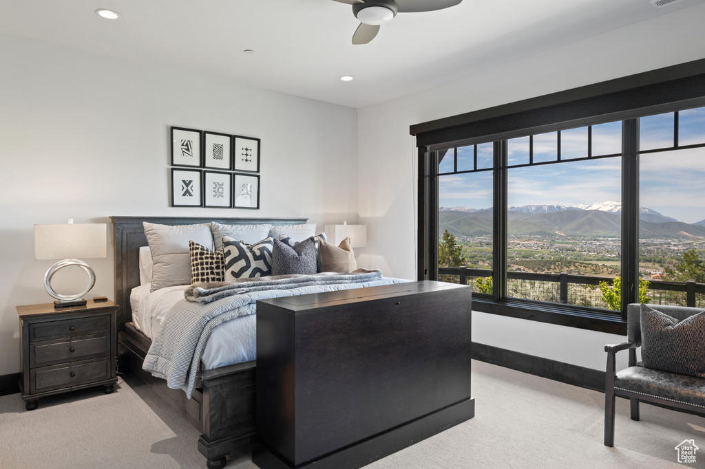 Bedroom featuring multiple windows, a mountain view, recessed lighting, light colored carpet, and ceiling fan