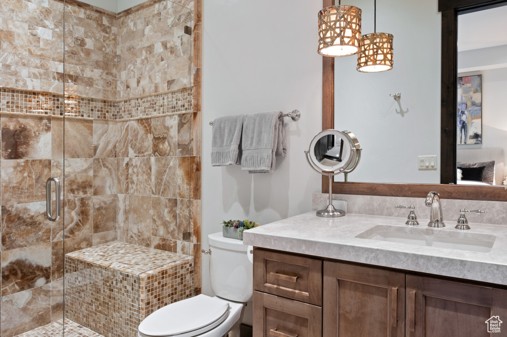 Bathroom with a stall shower, vanity, and toilet