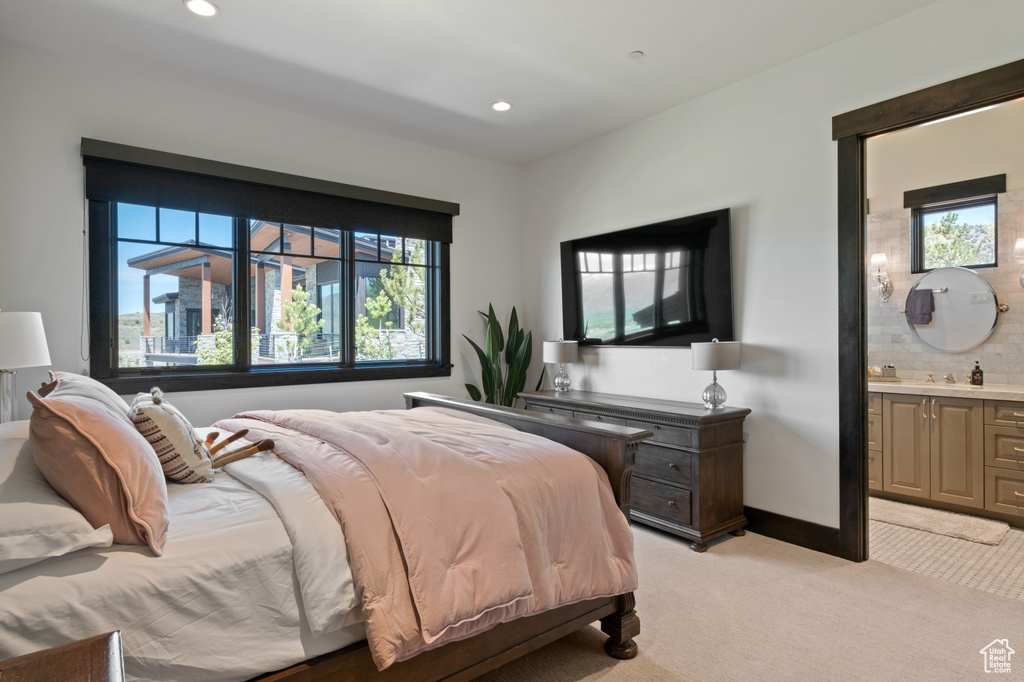 Bedroom with light carpet, ensuite bath, recessed lighting, and baseboards
