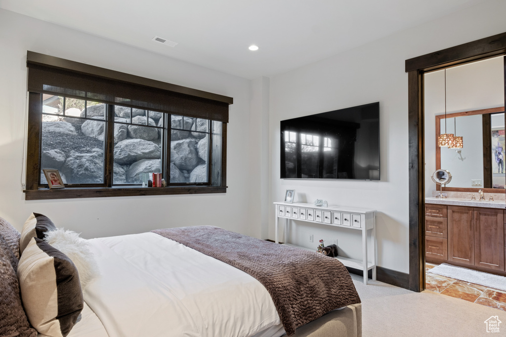 Bedroom featuring light carpet, recessed lighting, ensuite bathroom, and baseboards