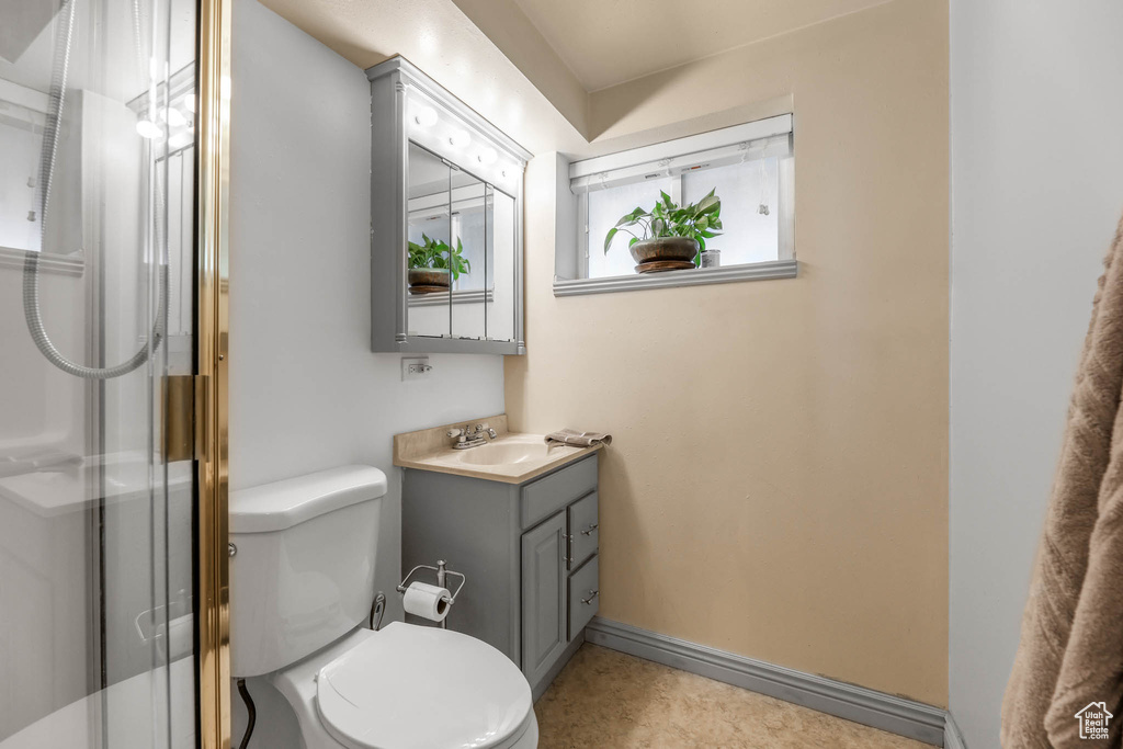 Bathroom with vanity, a stall shower, and toilet