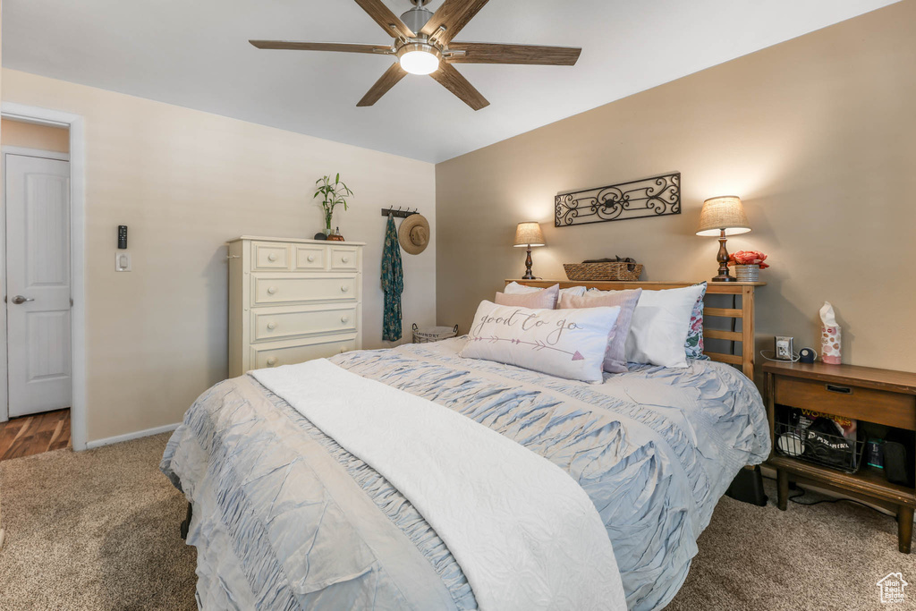 Carpeted bedroom with baseboards and a ceiling fan