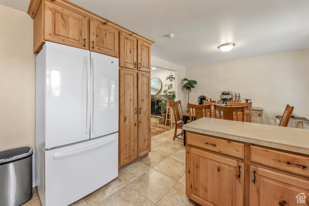 Kitchen featuring freestanding refrigerator and light countertops