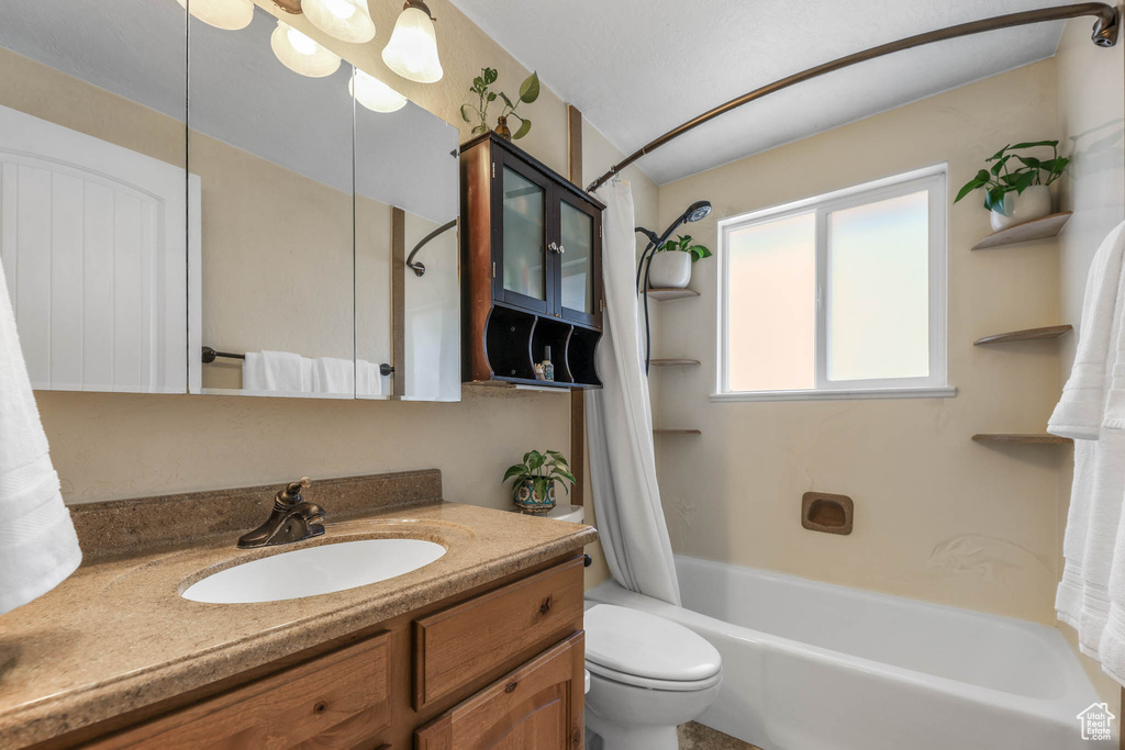 Full bathroom featuring vanity, toilet, and shower / tub combo