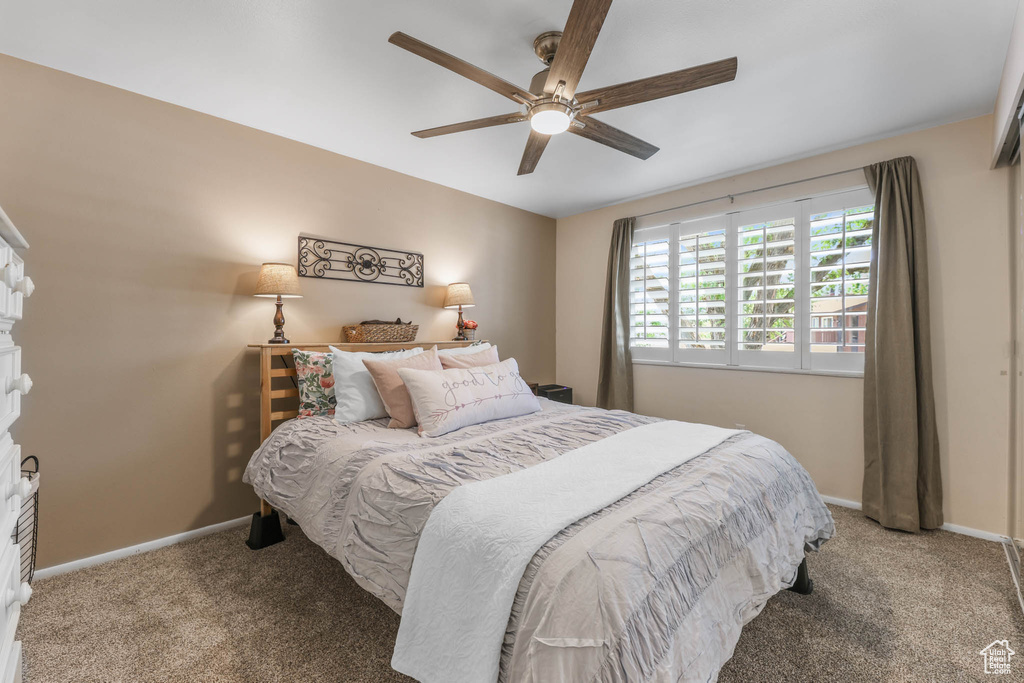 Carpeted bedroom with baseboards and a ceiling fan