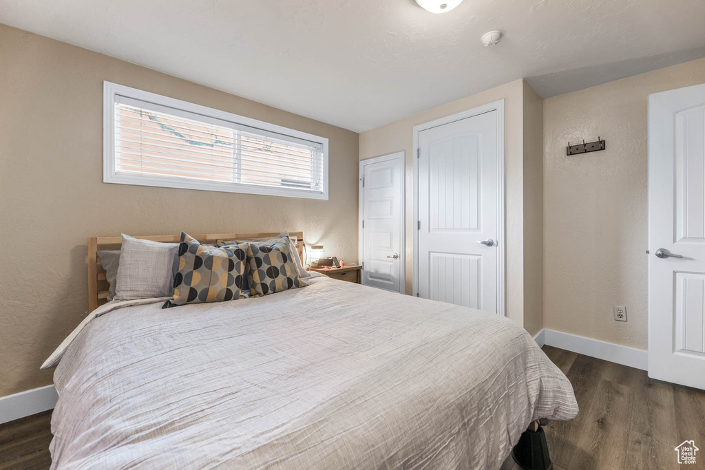 Bedroom with wood finished floors and baseboards