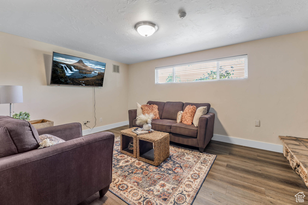 Living area with baseboards and wood finished floors