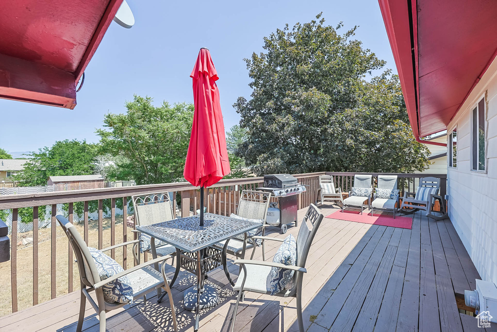 Wooden deck featuring outdoor dining space and area for grilling