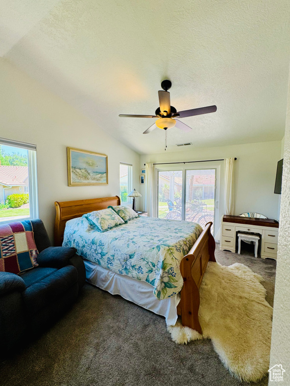Carpeted bedroom with access to outside, multiple windows, vaulted ceiling, ceiling fan, and a textured ceiling