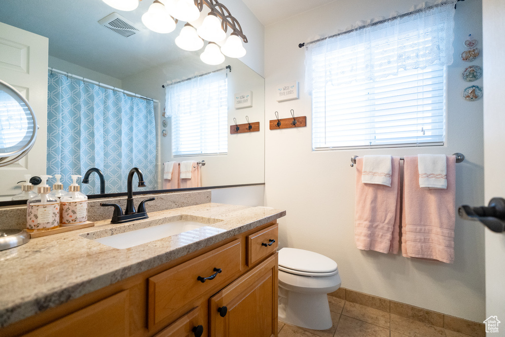 Full bathroom featuring vanity, tile patterned flooring, toilet, and baseboards