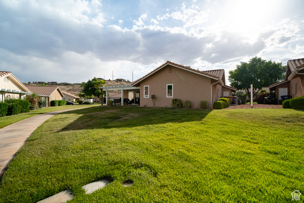 View of grassy yard featuring a pergola