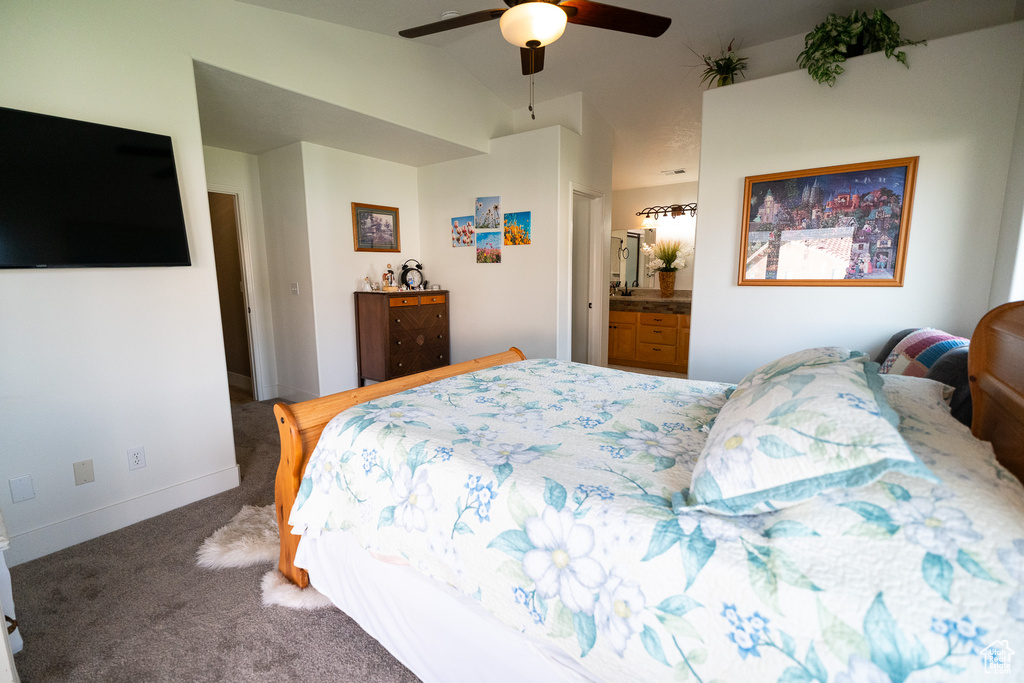 Bedroom with carpet flooring, lofted ceiling, baseboards, a ceiling fan, and ensuite bath