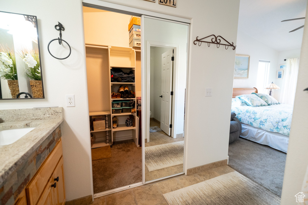 Bathroom featuring vanity, ensuite bath, ceiling fan, and lofted ceiling
