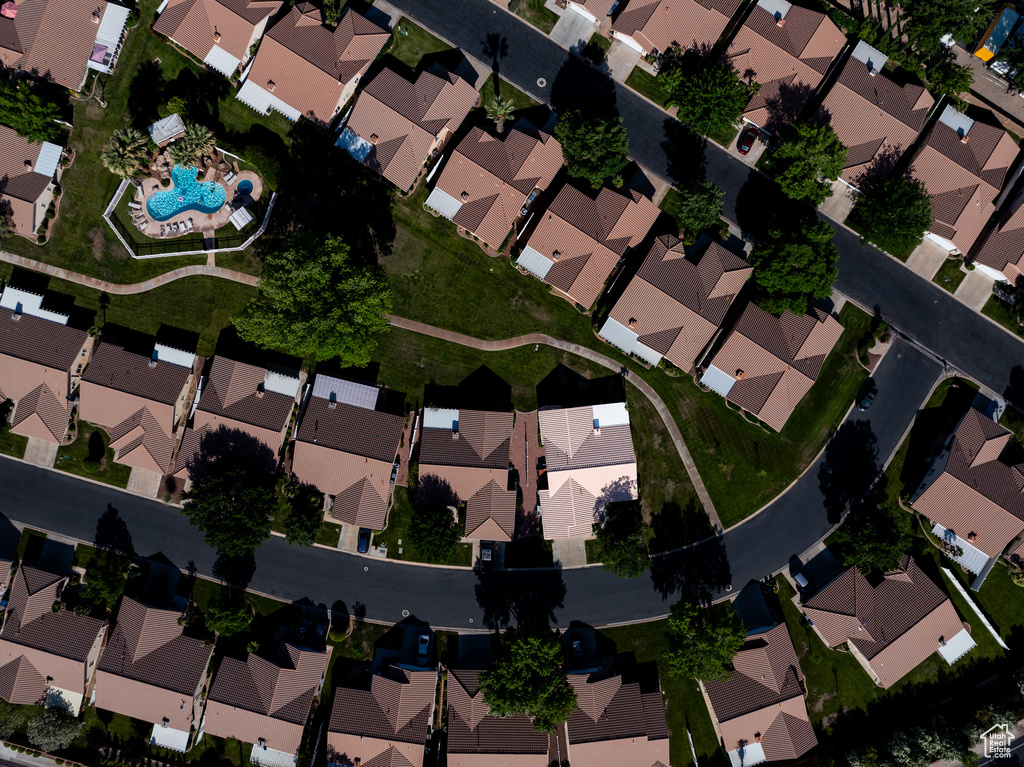 Aerial view of property and surrounding area featuring nearby suburban area and a pool