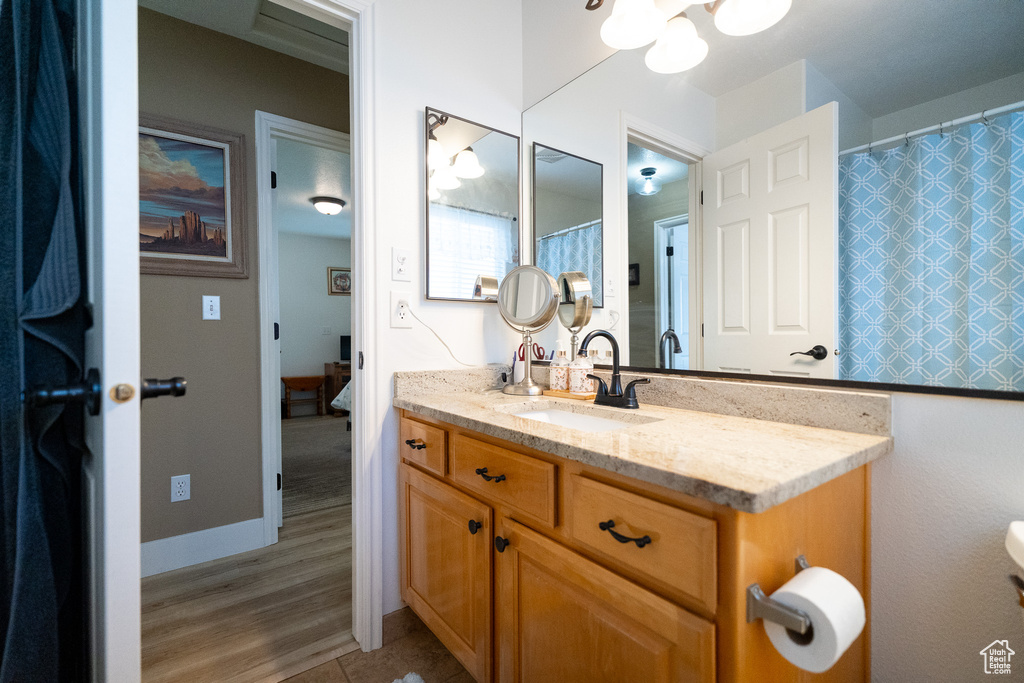Bathroom with vanity, a chandelier, and wood finished floors