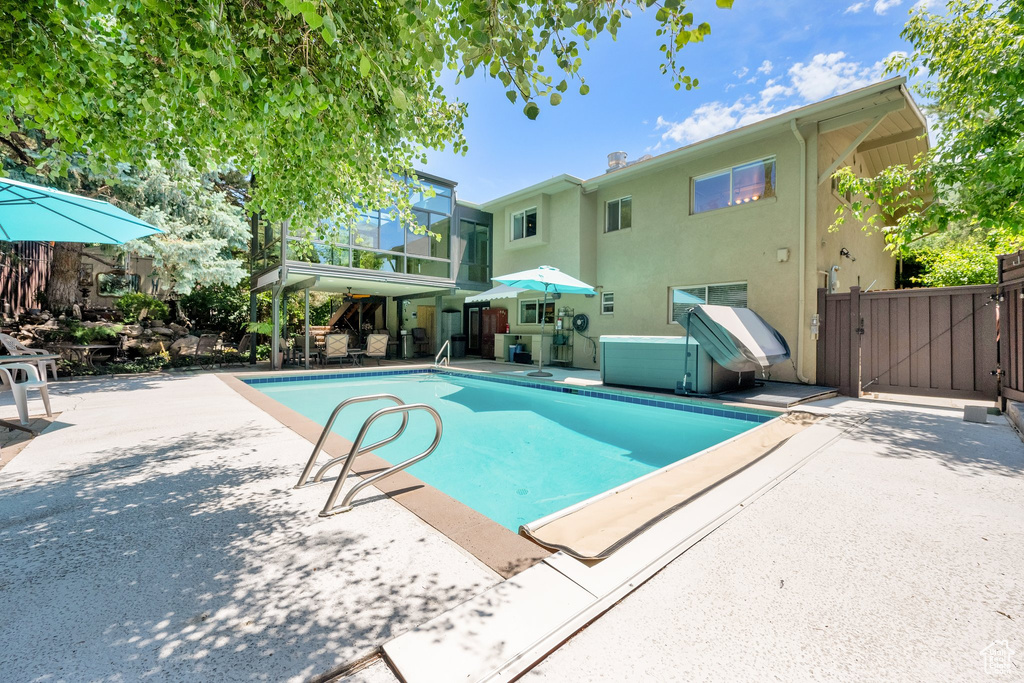 View of swimming pool with a patio and a gate