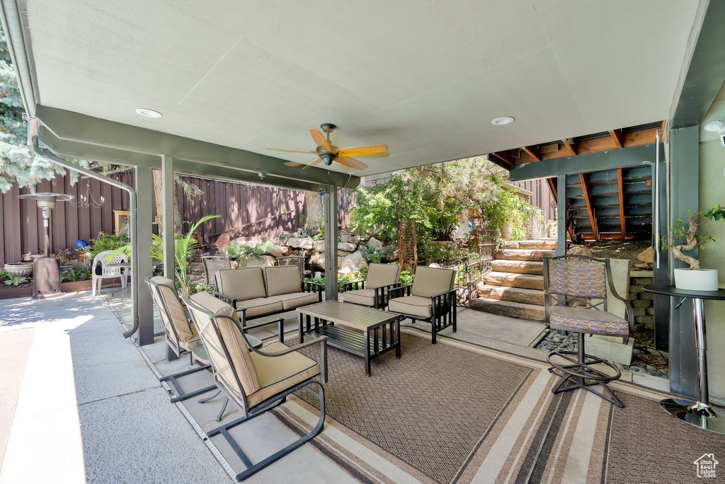 View of patio / terrace featuring an outdoor living space, a ceiling fan, and stairs