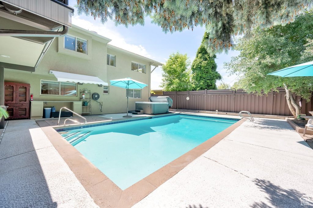View of swimming pool featuring a patio area and a fenced backyard