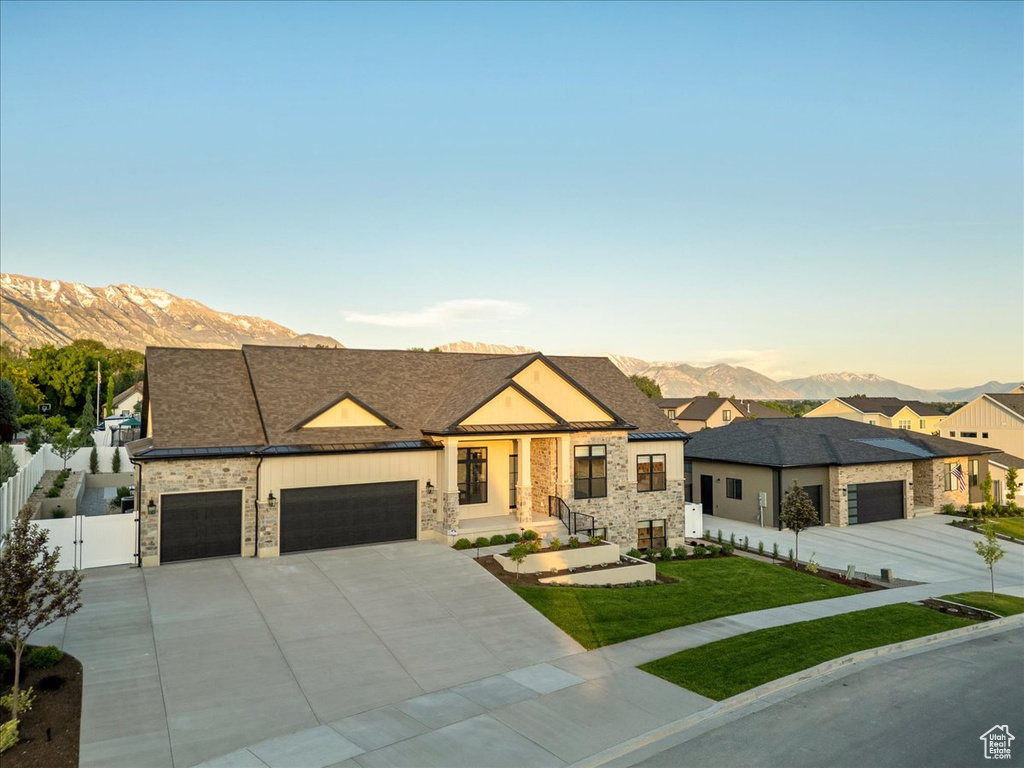 View of front of home featuring a mountain view, an attached garage, a gate, and concrete driveway