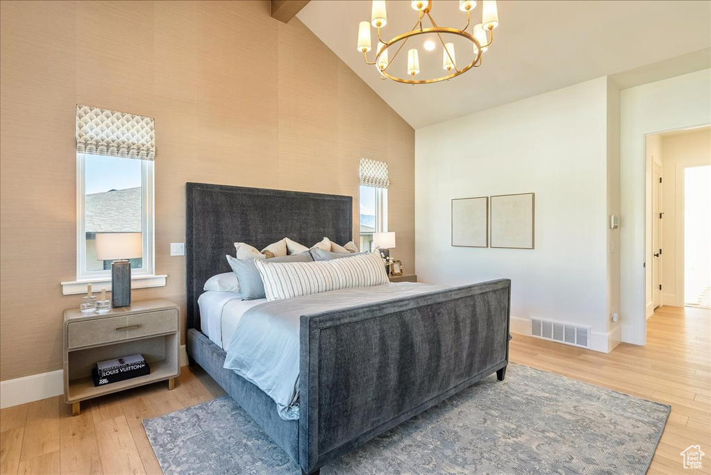 Bedroom featuring a chandelier, light wood finished floors, baseboards, high vaulted ceiling, and beamed ceiling