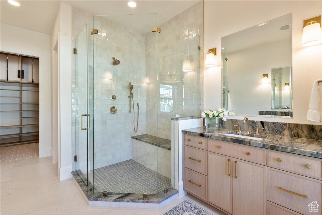 Bathroom with vanity, a stall shower, tile patterned floors, and recessed lighting