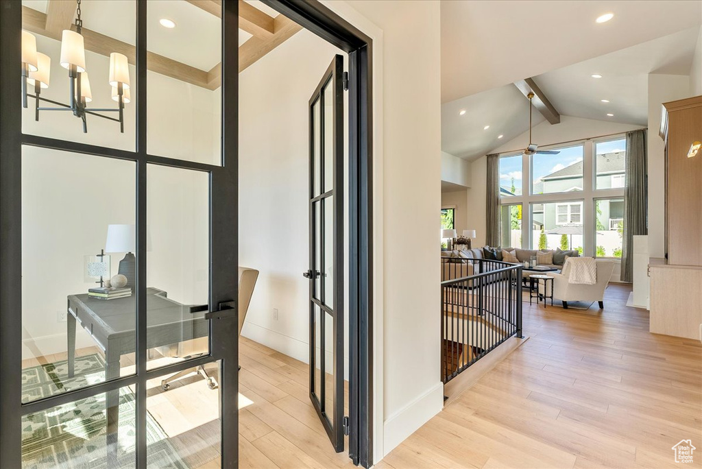 Hall featuring high vaulted ceiling, beamed ceiling, light wood-type flooring, baseboards, and a chandelier
