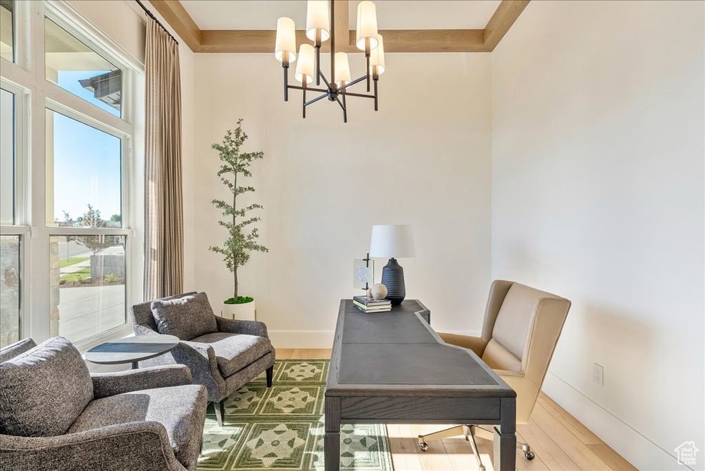 Office featuring a chandelier, wood finished floors, baseboards, and a towering ceiling